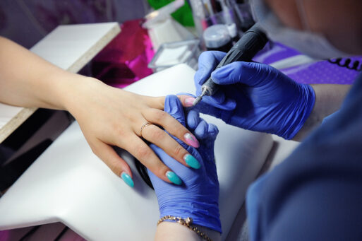 Repair old gel nails with a nail grinder in the nail salon. The process of replacing old gel nails with new ones.
маникюр