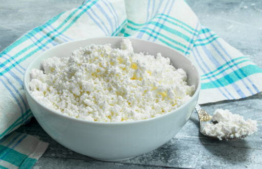 Cottage cheese in bowl on napkin. On a rustic background.