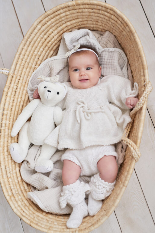 Cute baby girl in knitted clothes and wreath with teddy bear toy. Children Protection Day. Mother's day greeting card. International day of happiness.
Дитя младенец