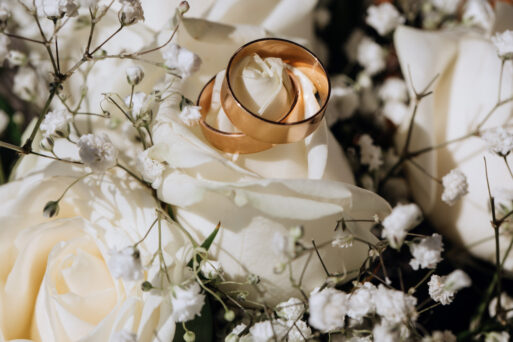 Golden wedding rings on the white rose  from the wedding bouquet
свадьба