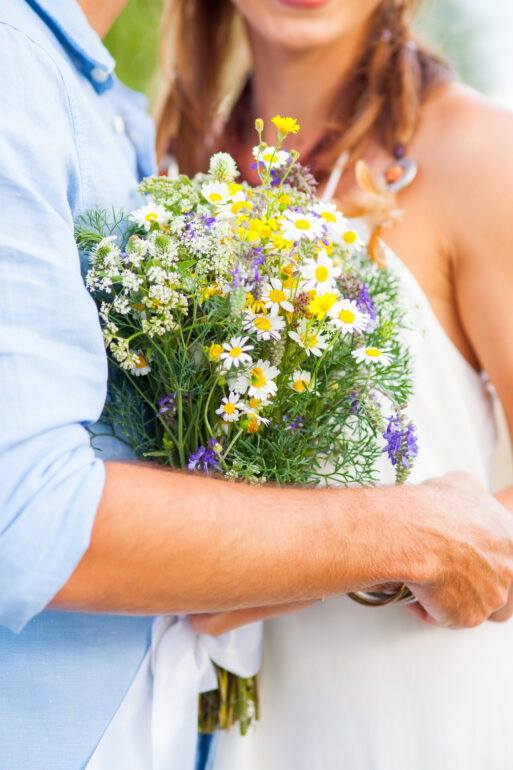 The crop image of romantic couple with flowers against green grass
Свадьба