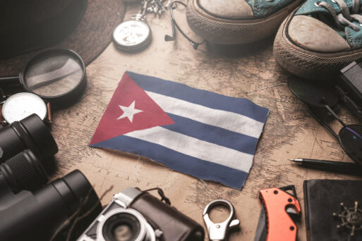 Cuba Flag Between Traveler's Accessories on Old Vintage Map. Tourist Destination Concept.
Куба