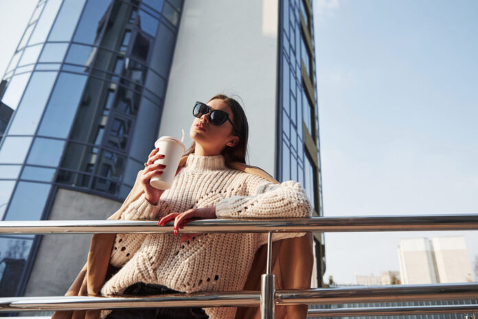 In knitted sweater. Young beautiful girl in warm clothes have walk in the city at her weekends time